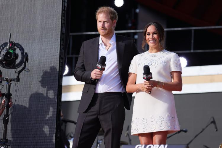 Il principe Harry e la moglie Meghan con il microfono in mano