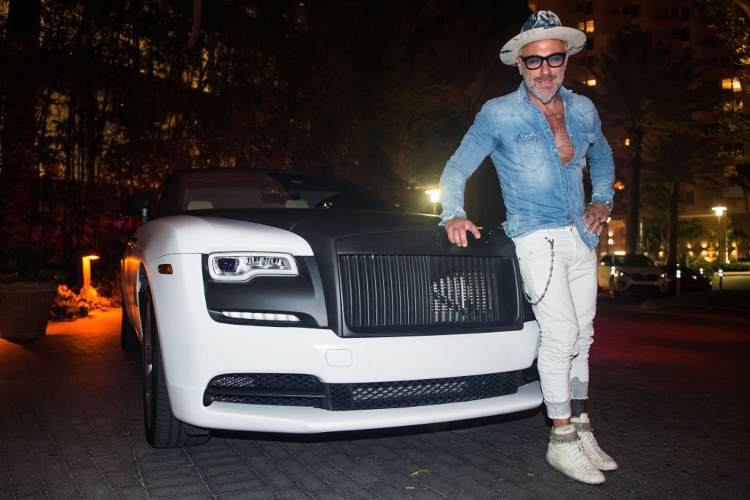Gianluca Vacchi di fronte a un'auto di lusso